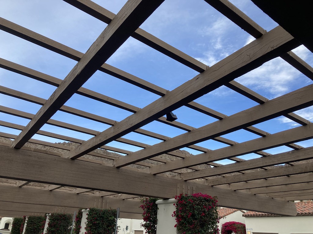 A carport is a big flat sail on legs — the footings and bracing decide its life — Photo: artisanalpv (CC BY-SA 2.0)