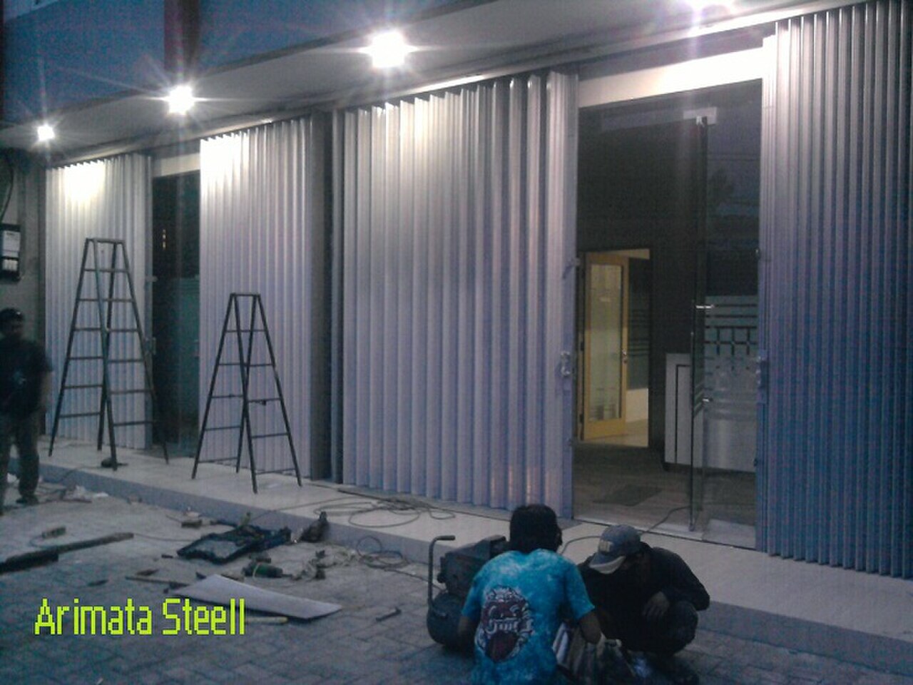 Steel gate patterns: the design decides the fabrication hours — Photo: Arimata Folding Gate (CC BY-SA 3.0)